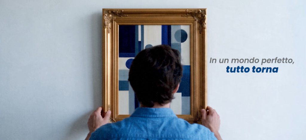Persona che posiziona una cornice dorata davanti a un quadro geometrico blu, immagine dell’articolo Fitlock sulla perfezione e sulla progettazione.